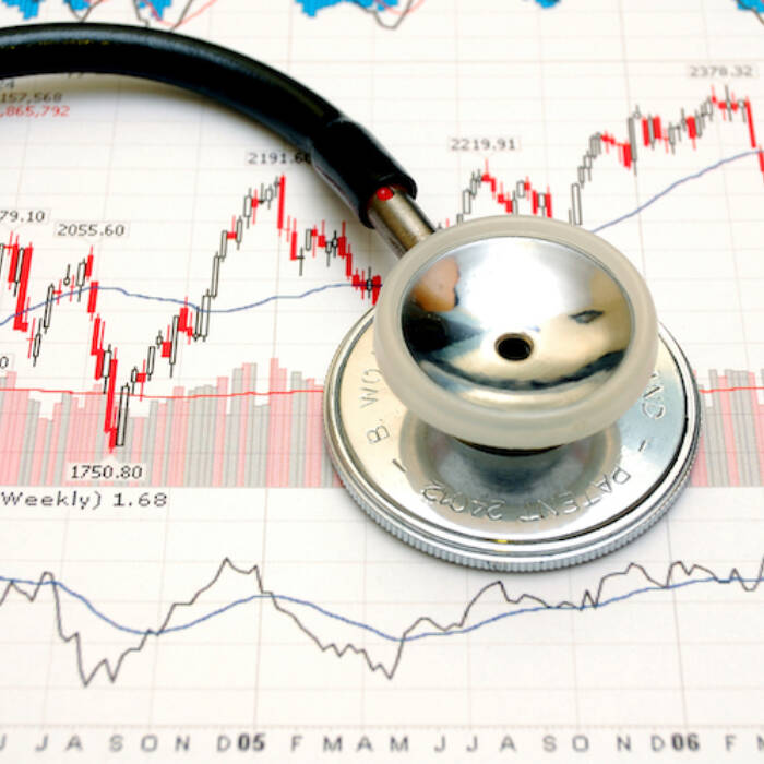 A stethoscope is sitting on stock market documents
