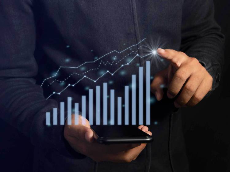 Holographic investment graph showing positive, increased investment returns, projected over a cell phone, in front of a person