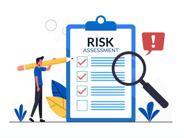 Risk assessment written on a sheet of paper on a clipboard with a magnifying glass hovering over it