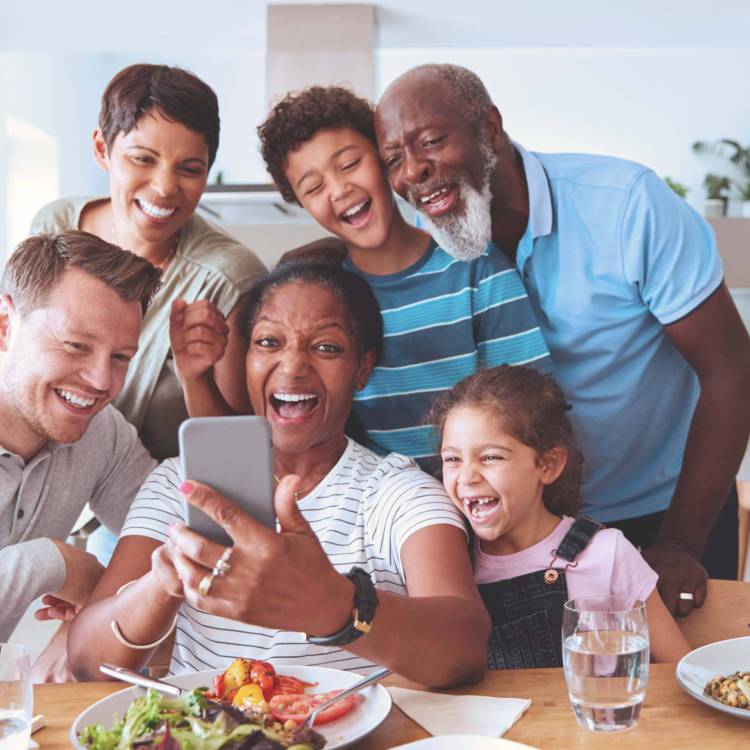 Family with two young children, middle aged father and mother as well as a grandfather and grandmother all taking a selfie