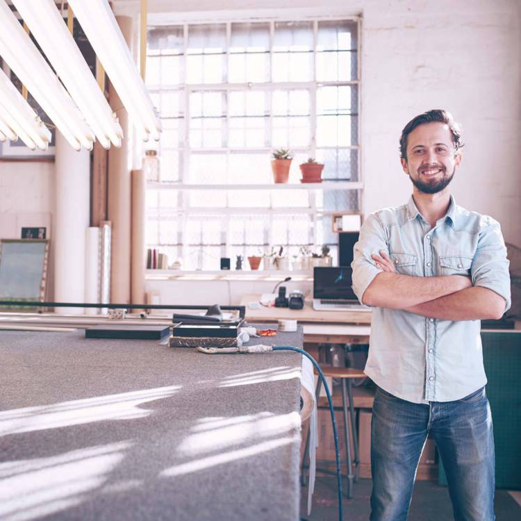 Private business owner standing happily in the middle of his warehouse workplace