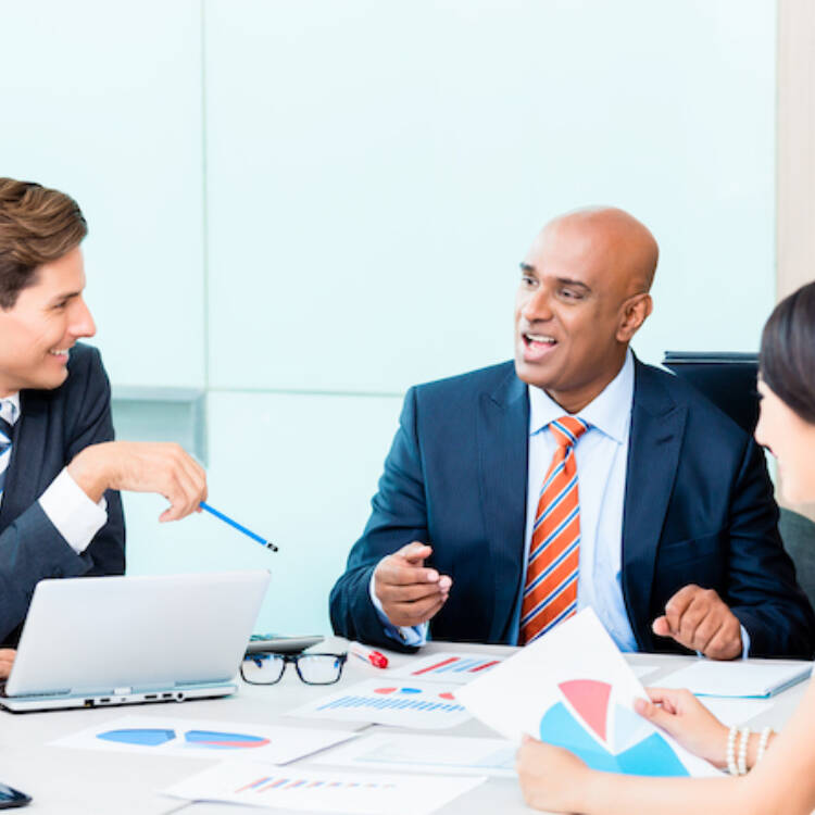 Group of unified team of investment financial advisors sitting around a table discussing financial matters