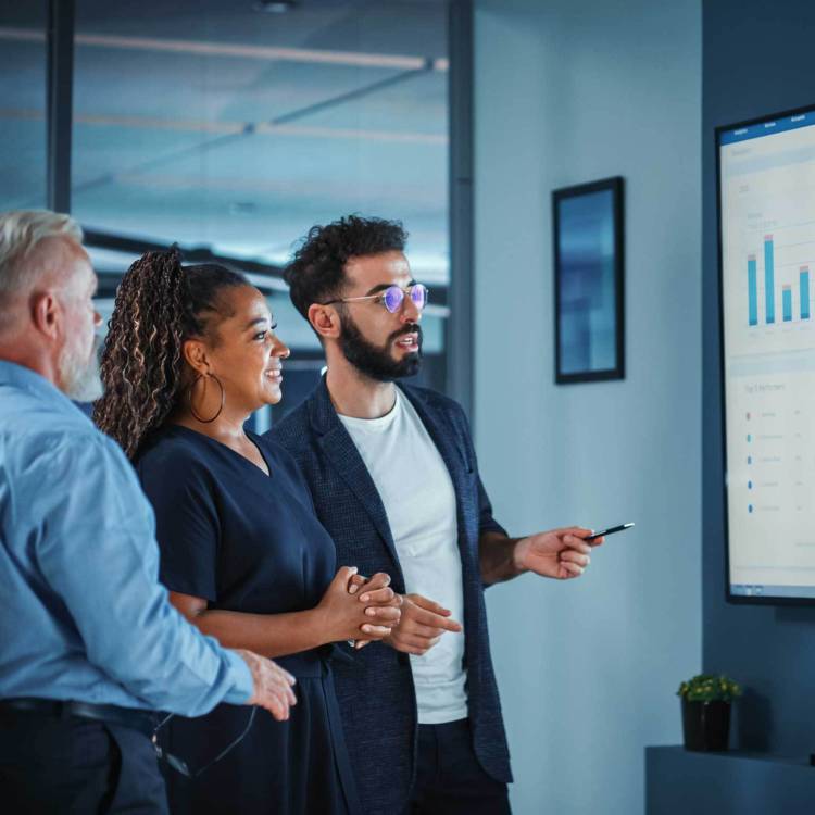Three executives reviewing and discussing financial and wealth management