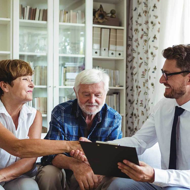 Fiduciary investor and financial advisor shaking hands with one of the two retired elderly client couple's hand