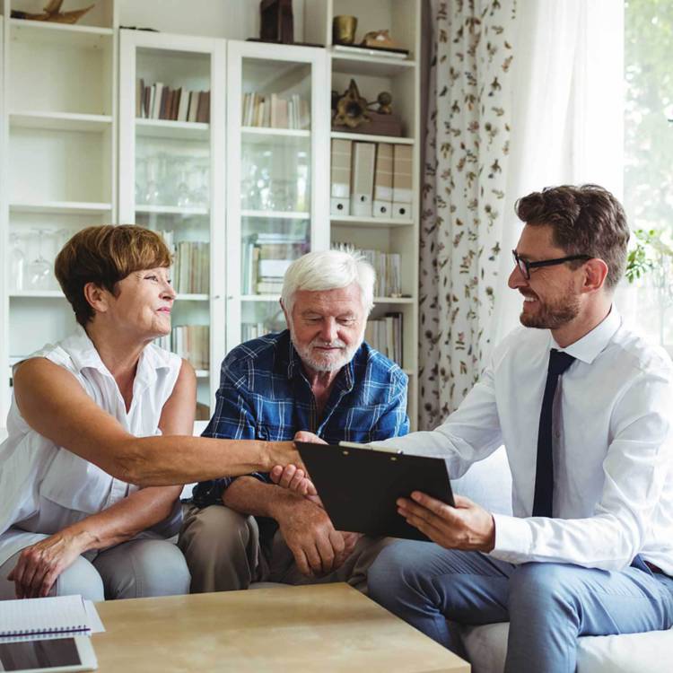 Fiduciary investor and financial advisor shaking hands with one of the two retired elderly client couple's hand