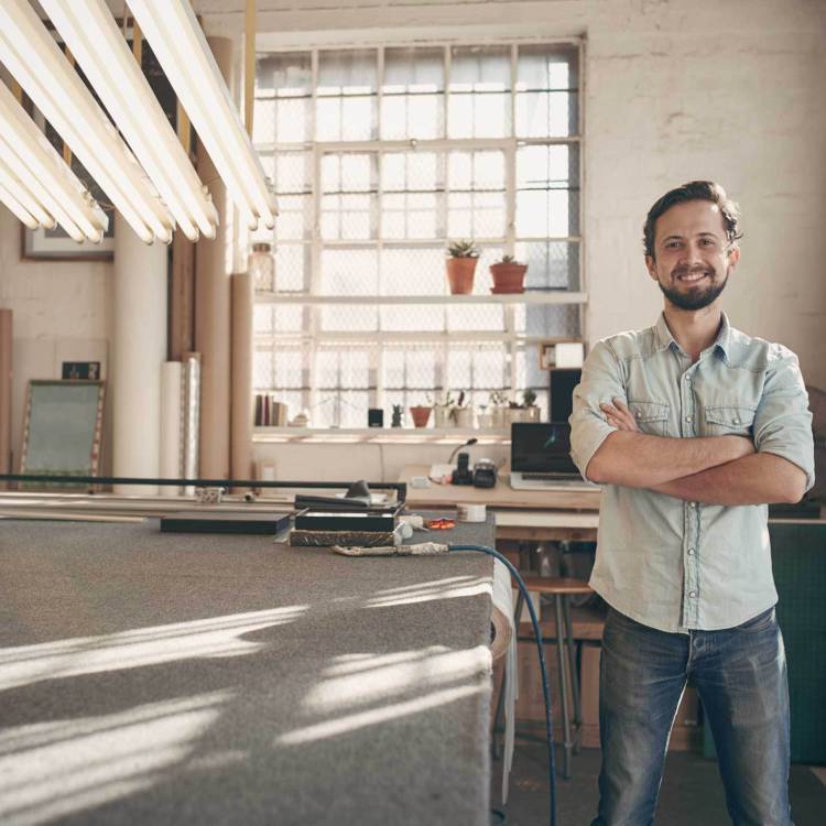 Private business owner standing happily in the middle of his warehouse workplace