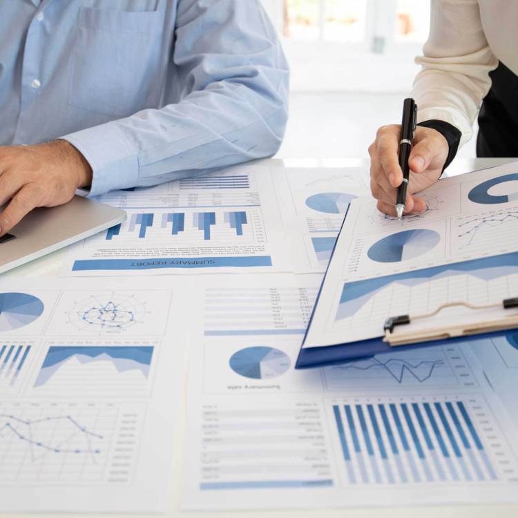 Two fiduciary investors and advisors looking over a diversified portfolio and financial data
