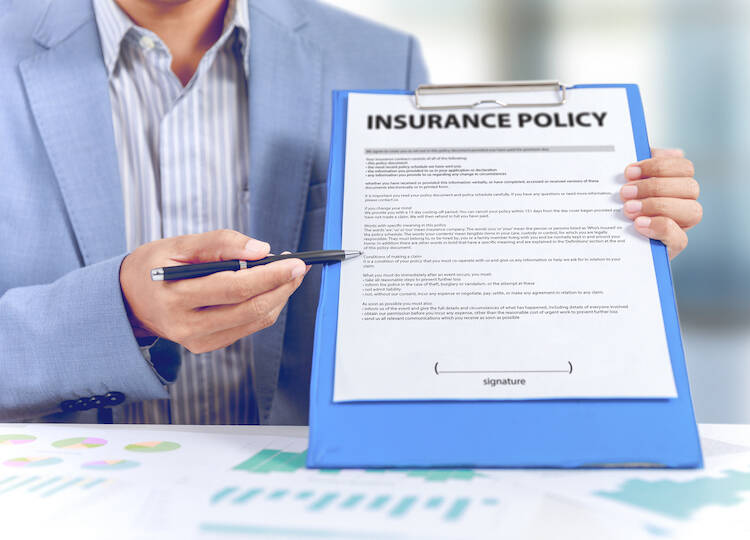 Fiduciary investment financial advisor holding a pen and clipboard pointing to an insurance document