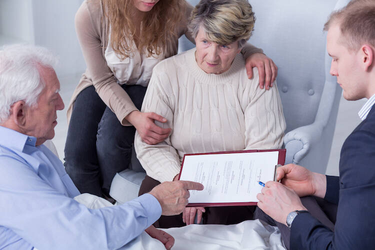 Retired elderly couple with their daughter discussing medical and health care matters with financial advisor