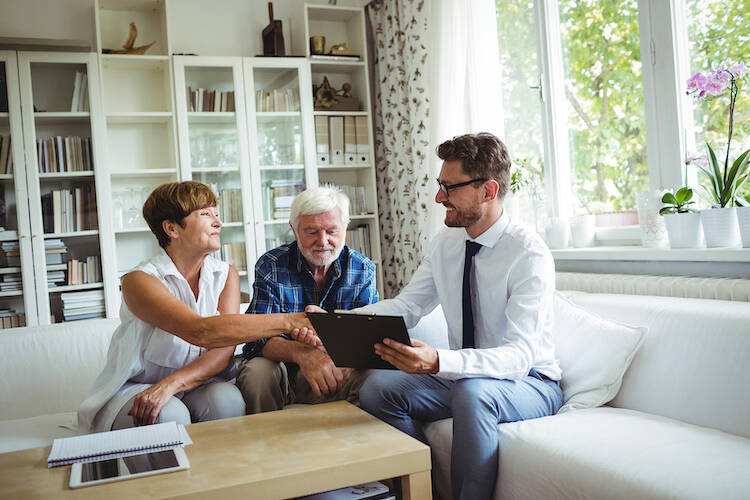 Fiduciary investor and financial advisor shaking hands with one of the two retired elderly client couple's hand