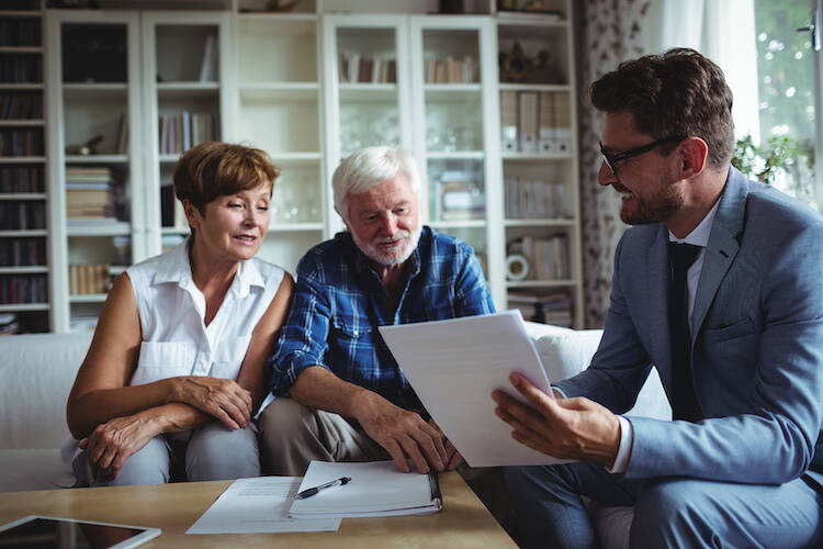 Fiduciary investor and advisor explaining financial matters with retired elderly client couple