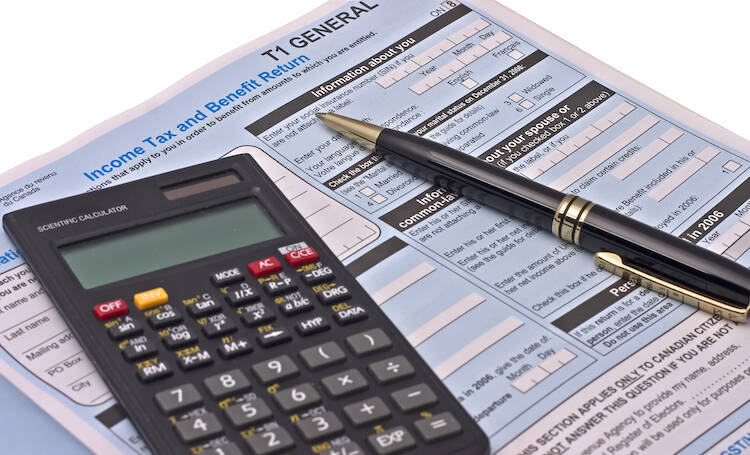 Canadian Tax Forms with a calculator and pen sitting on the documents
