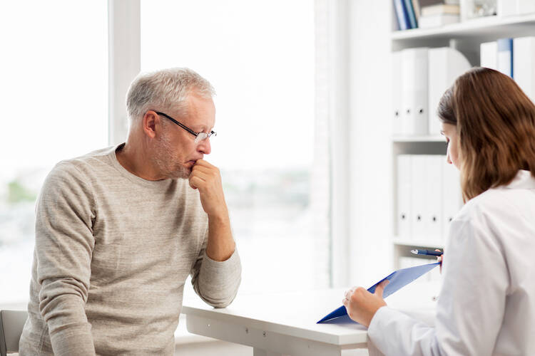 Retired elderly client sitting with a medical professional discussing health care matters