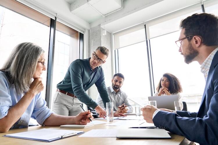 Five accountants sitting around a table discussing about maximizing their business by partnering with a wealth management firm