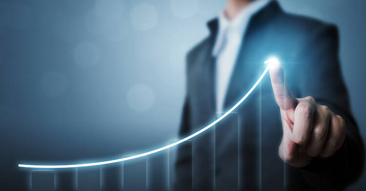 A person is pointing at a holographic image of a stock graph