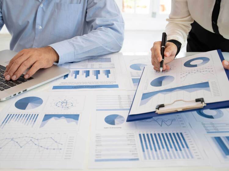 Two fiduciary investors and advisors looking over a diversified portfolio and financial data